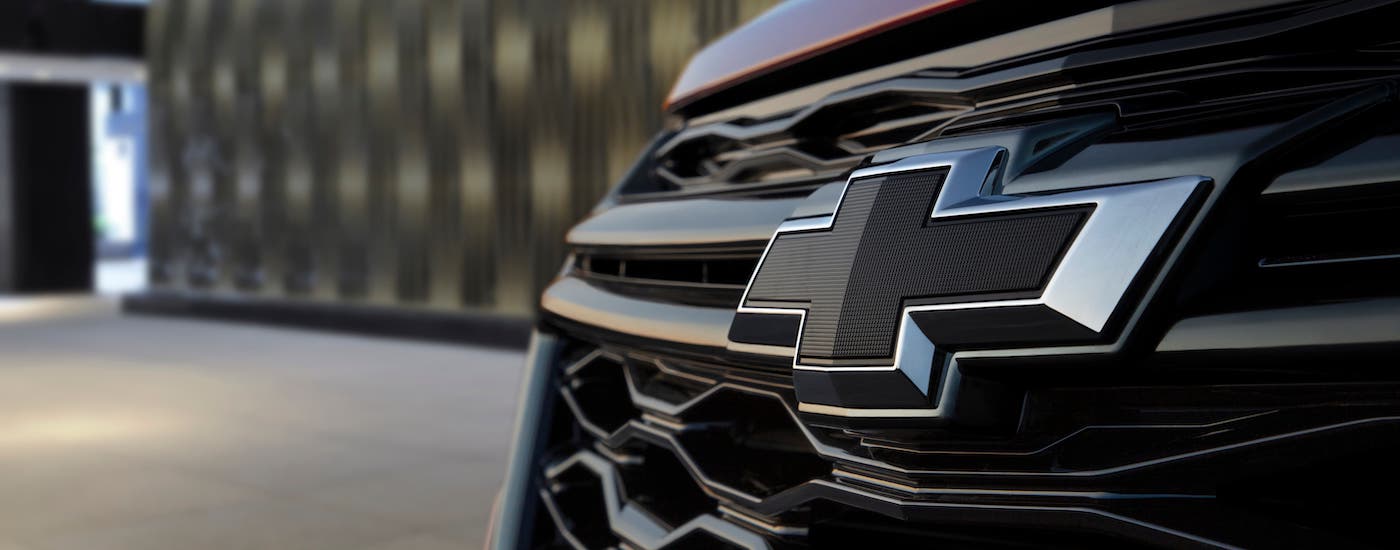 A closeup shows the black Chevrolet badging on a 2022 Chevy Equinox RS parked at a Chevy dealer near you.
