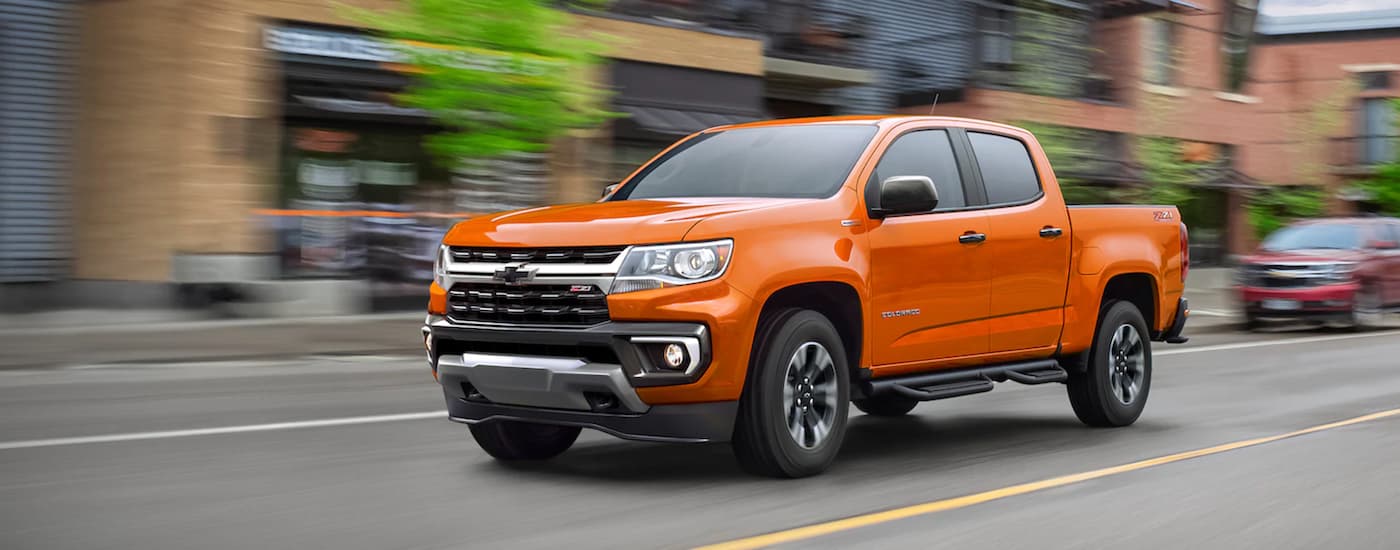 An orange 2021 Chevy Colorado Z71 is shown from the front at an angle after leaving a dealer that has used trucks for sale near Spring, TX.