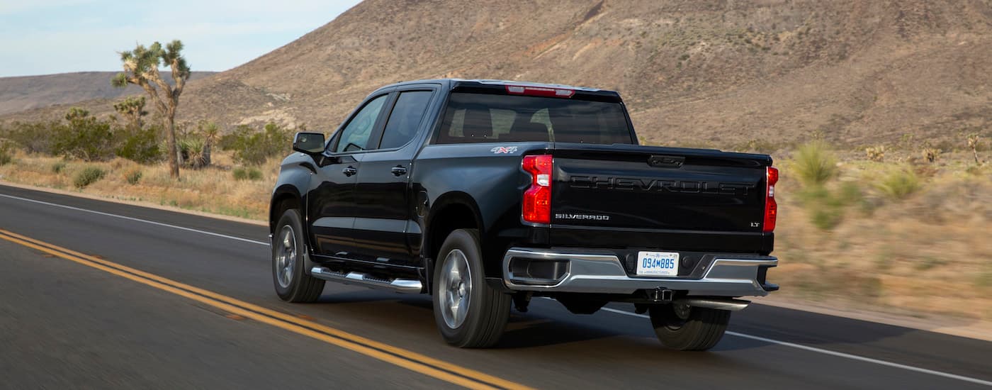 A black 2022 Chevy Silverado 1500 LT is shown from the rear at an angle.