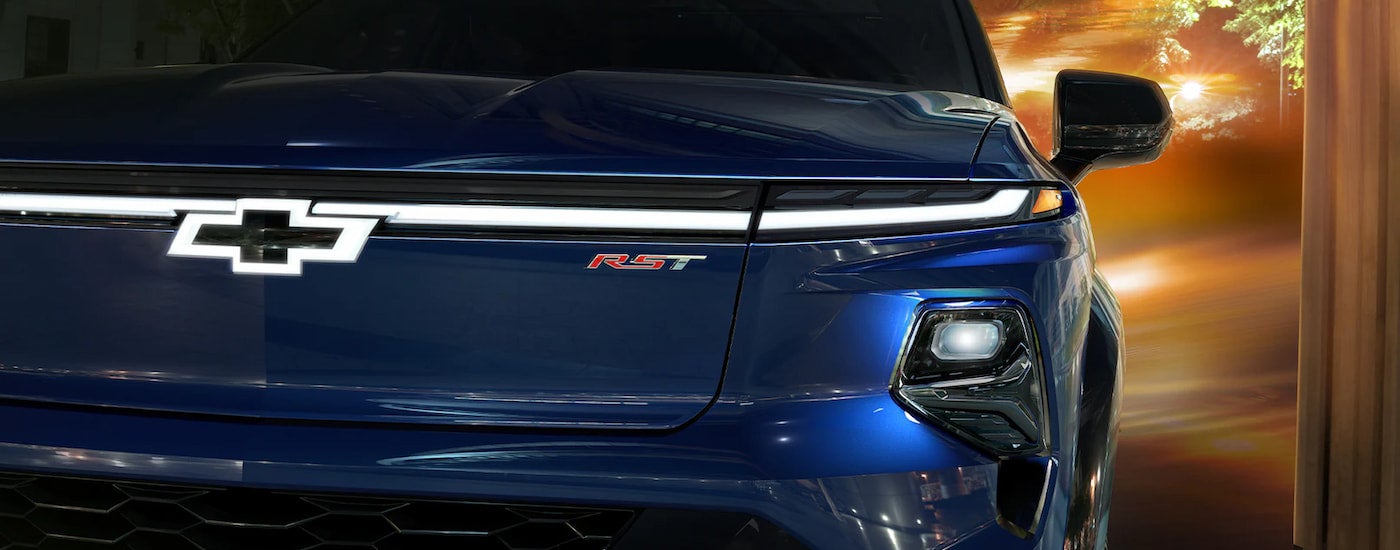 A close up shows the front of a blue 2024 Chevy Silverado EV RST.