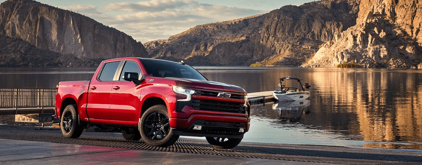 A red 2023 Chevy Silverado 1500 LTZ Z71 is shown parked next to a lake after leaving a Chevy Silverado dealer.