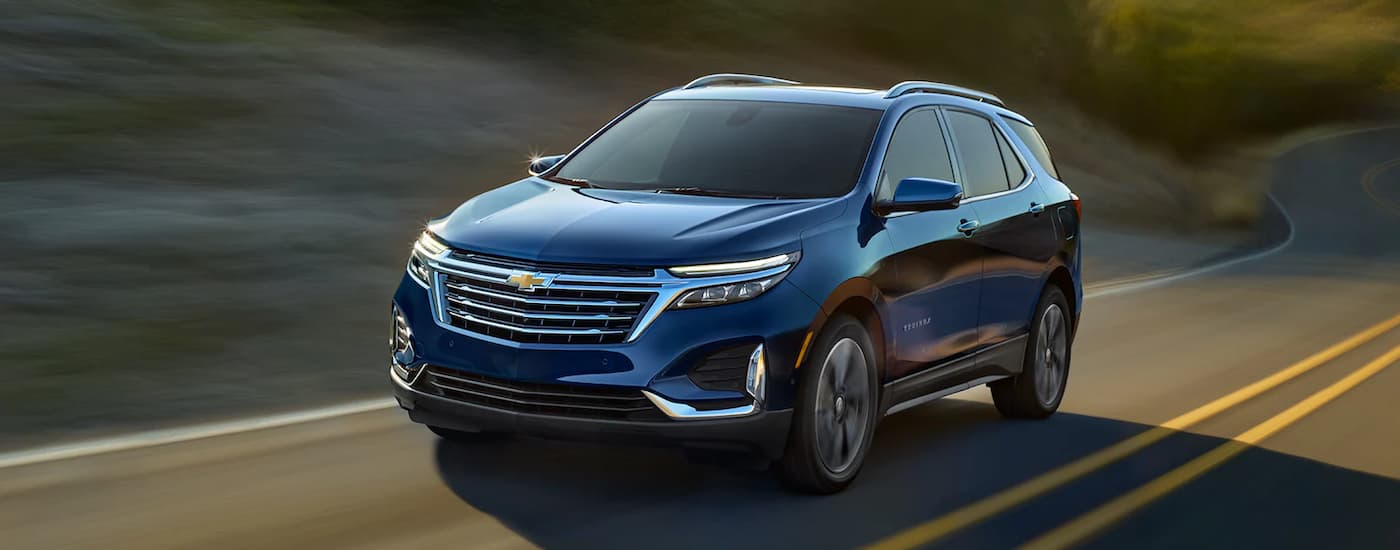 A blue 2022 Chevy Equinox is shown on a highway after leaving The Woodlands Chevrolet dealership.