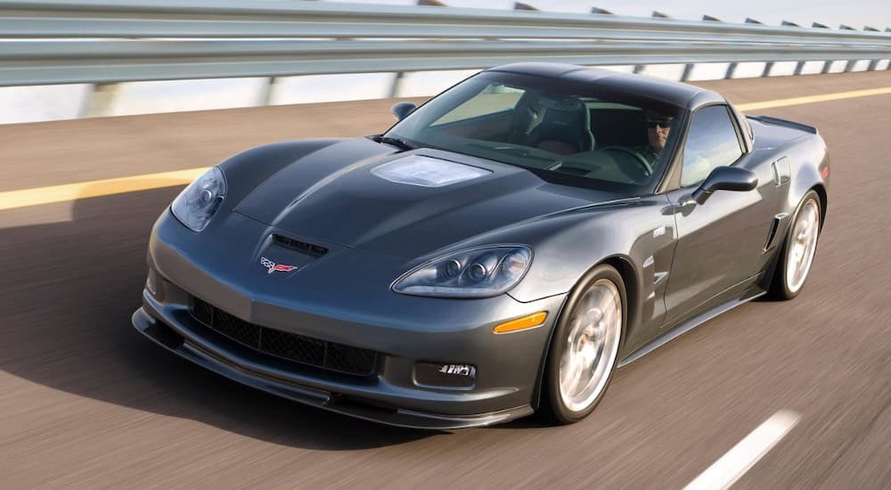 A grey 2009 Chevrolet Corvette ZR1 is driving on a highway leaving a used Chevy dealer in Houston.