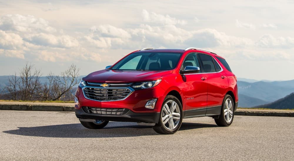 A red 2019 used Chevy Equinox is parked at a lookout with a view.