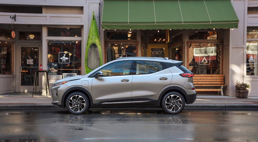 A silver 2022 Chevy Bolt EUV is parked in front of a store.