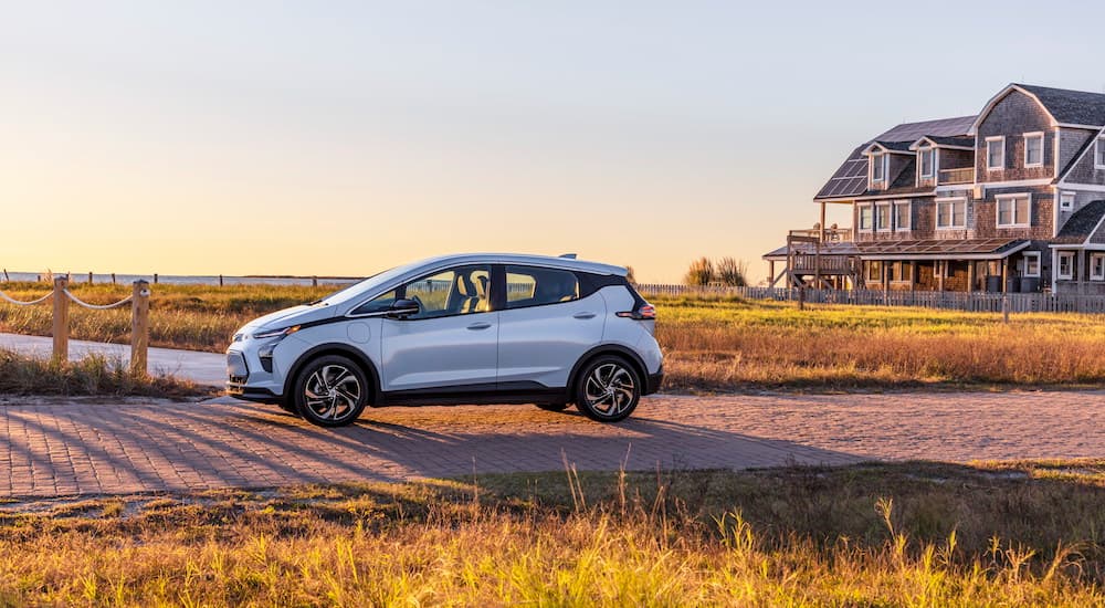 A silver 2022 Chevy Bolt EV is parked on a boardwalk at sunset.