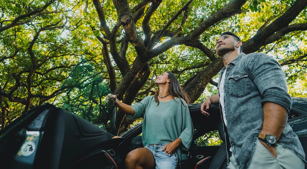 A couple is shown exiting a 2020 Chevy Camaro SS in the woods after leaving a used car lot near you.
