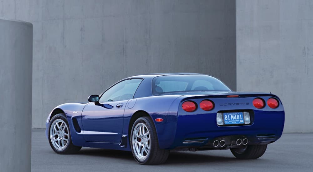 A blue 2004 Chevy Corvette is shown from a rear angle parked near one of the used Chevy dealers in Houston