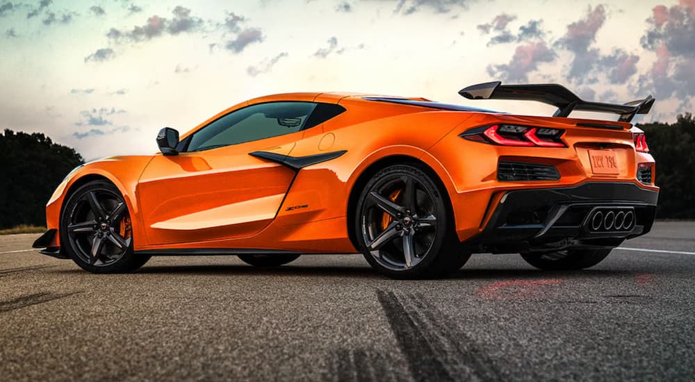 An orange 2021 Chevy Corvette Z06 is shown from the side parked on a street during the Chevy pre-order process.