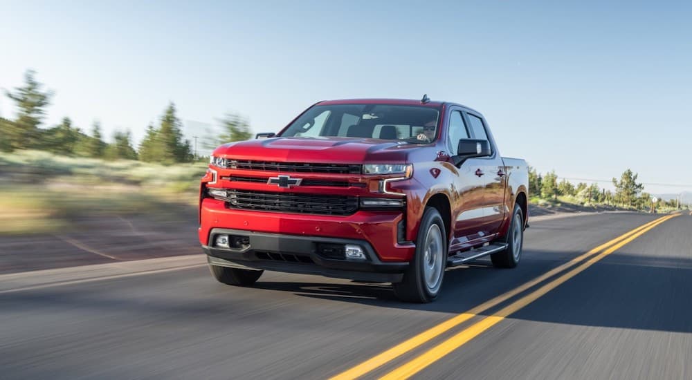 A red 2020 Chevy Silverado 1500 is shown driving on an open road.