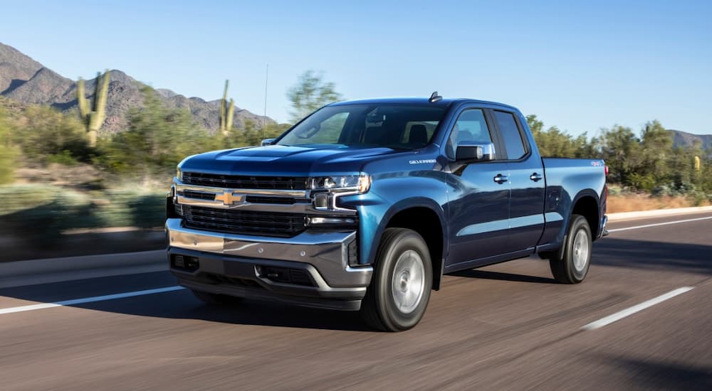A blue 2019 Chevy Silverado 1500 is shown driving on an open highway.