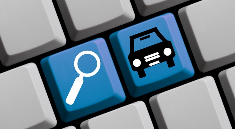 A blue car and blue search button are shown on a keyboard.