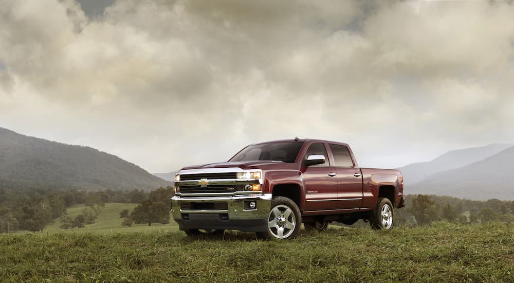 A maroon 2015 used Chevy Silverado 2500 HD Z71 is shown parked on a field .