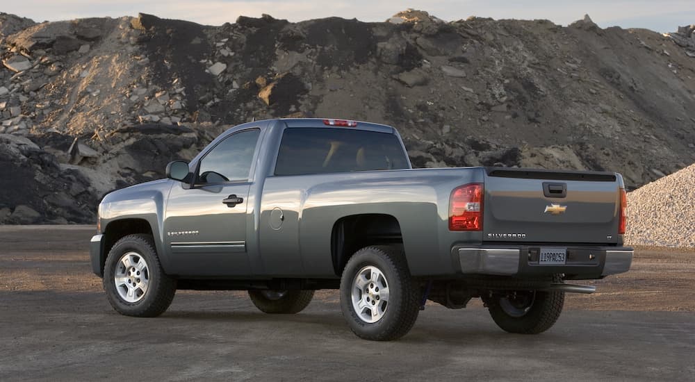 A grey 2009 Chevy Silverado 1500 is shown parked from the rear in the mountains.