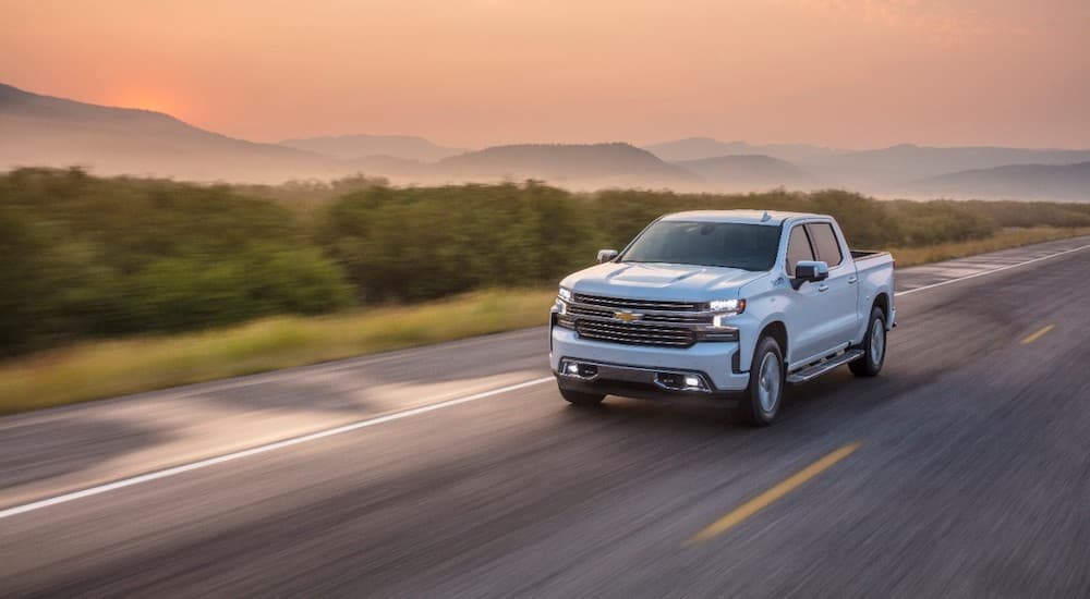 A white 2020 used Chevy Silverado 1500 is shown driving on an open road.