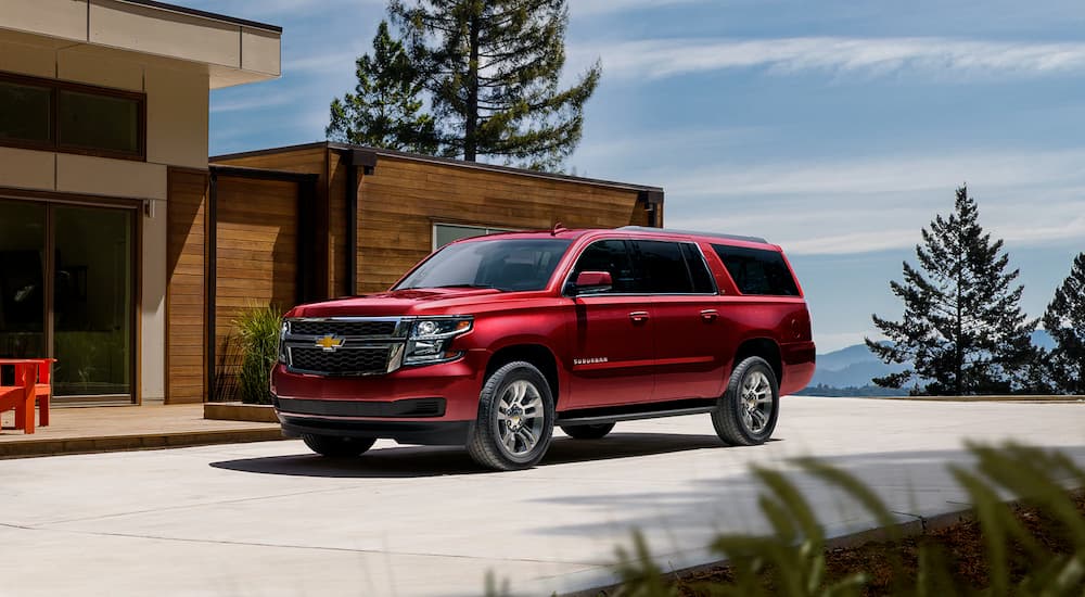 A red 2022 Chevy Suburban is shown in a driveway after leaving a Cypress Texas Chevy dealer.