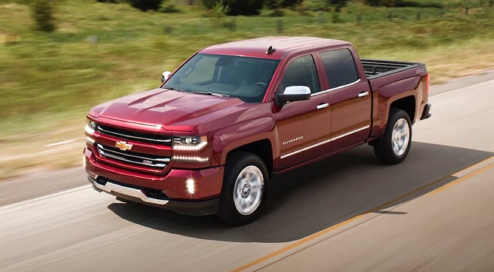 A maroon 2017 Chevy Silverado 1500 LTZ is shown driving on an open road.