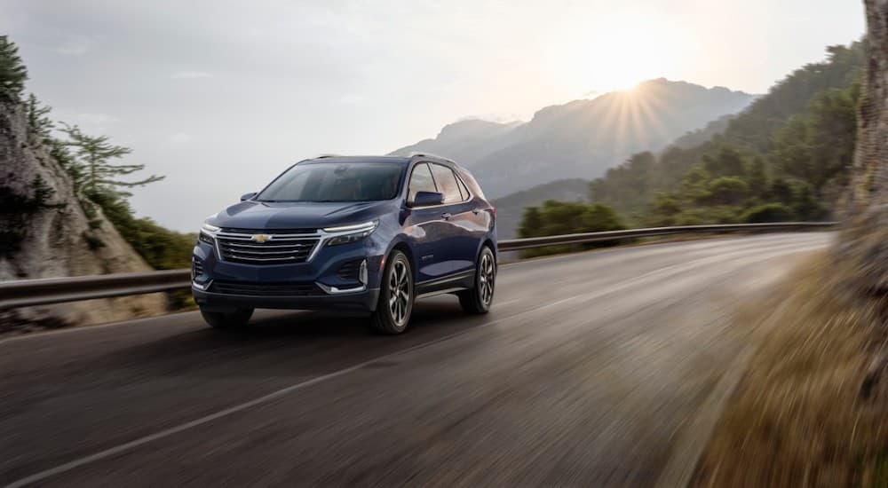 A blue 2022 Chevy Equinox is shown driving on an open road after leaving a Chevy Equinox dealership.