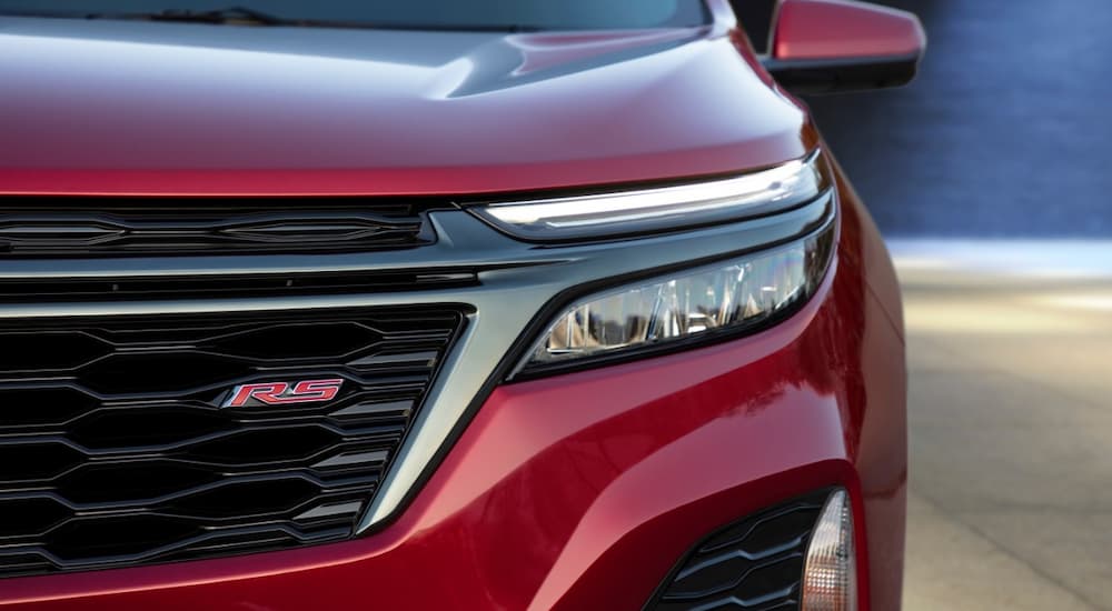 A close up of the headlight on a red 2022 Chevy Equinox RS is shown.
