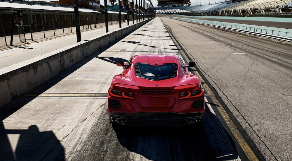A red 2022 Chevy Corvette is shown from the rear on a track.