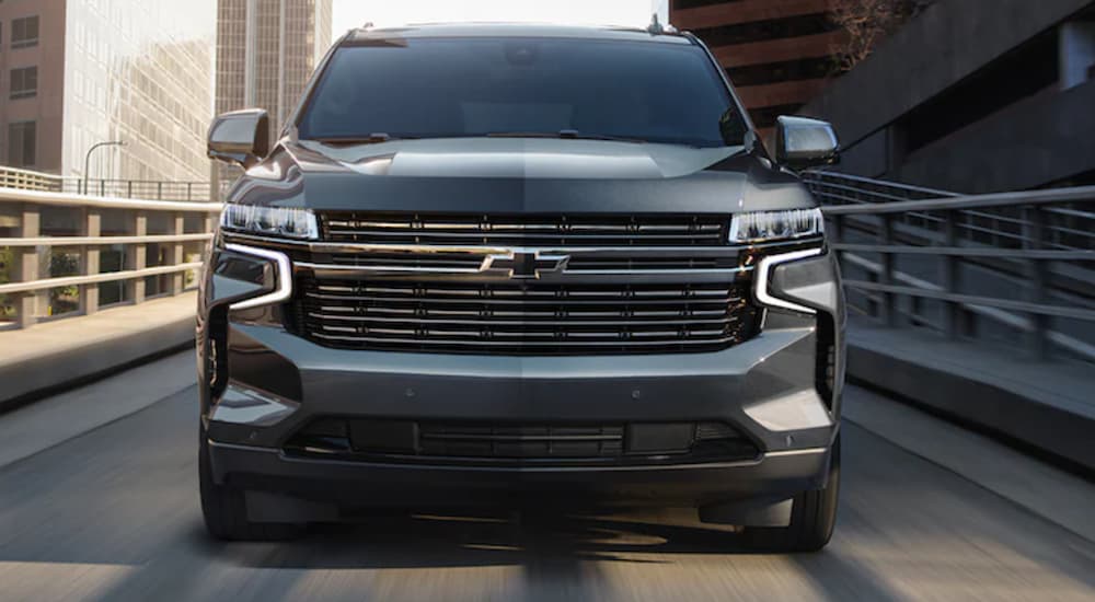 A black 2021 Chevy Tahoe is shown driving on a city road.