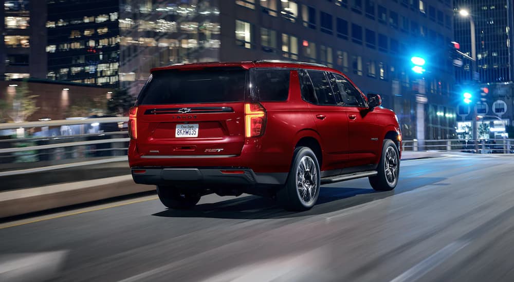 A red 2022 Chevy Tahoe is shown driving at night.