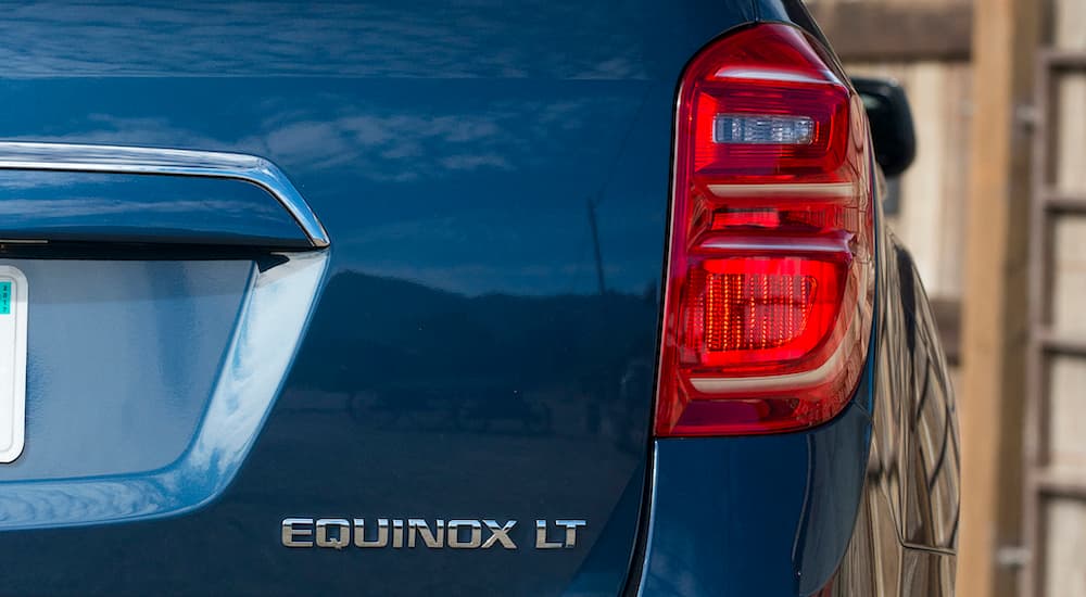 A close up shows the trunk badge and passenger side taillight on a blue 2016 Chevy Equinox LT.
