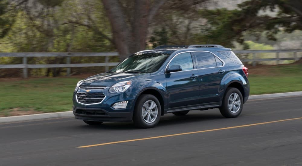 A blue 2016 Chevy Equinox is shown from the side while driving after leaving a dealer that has a used Chevy Equinox for sale near Houston.