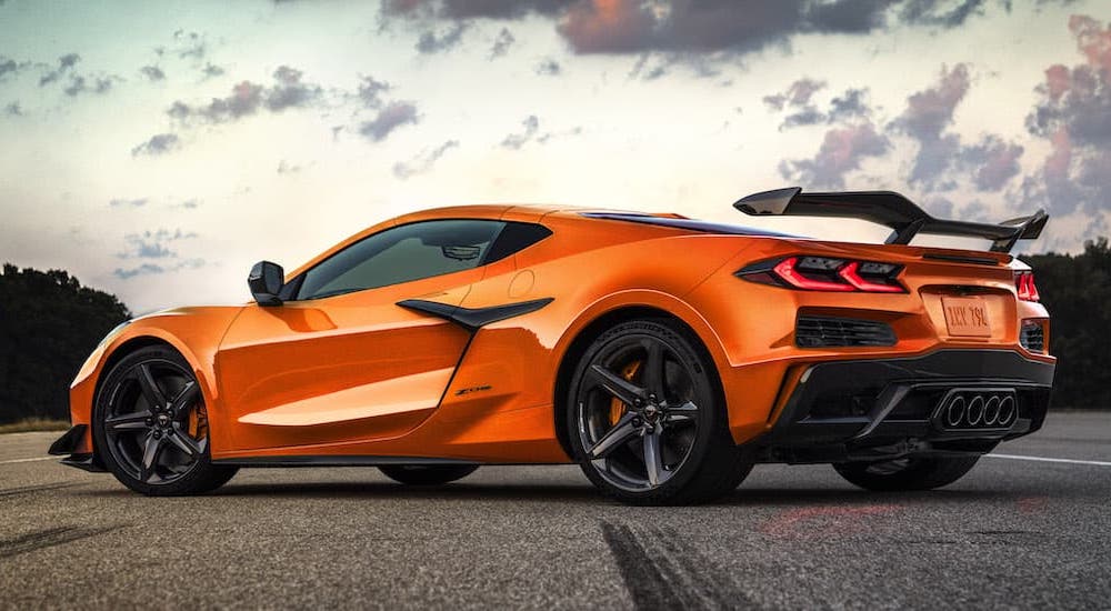 An orange 2023 Chevy Corvette Z06 is shown from the rear at an angle after leaving a Magnolia Chevy dealer.