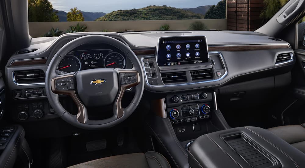 The black interior of a 2023 Chevy Suburban is shown from the driver's seat.