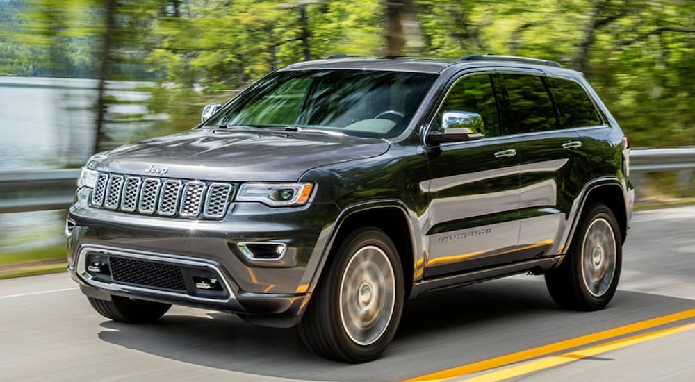 A grey 2020 Jeep Grand Cherokee is shown from the front after leaving a dealer that has used SUVs for sale.
