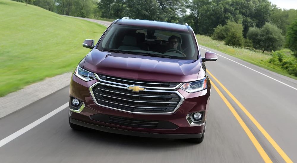 A purple 2018 Chevy Traverse is shown on an open road after looking at a used Chevy Traverse for sale near the Woodlands.