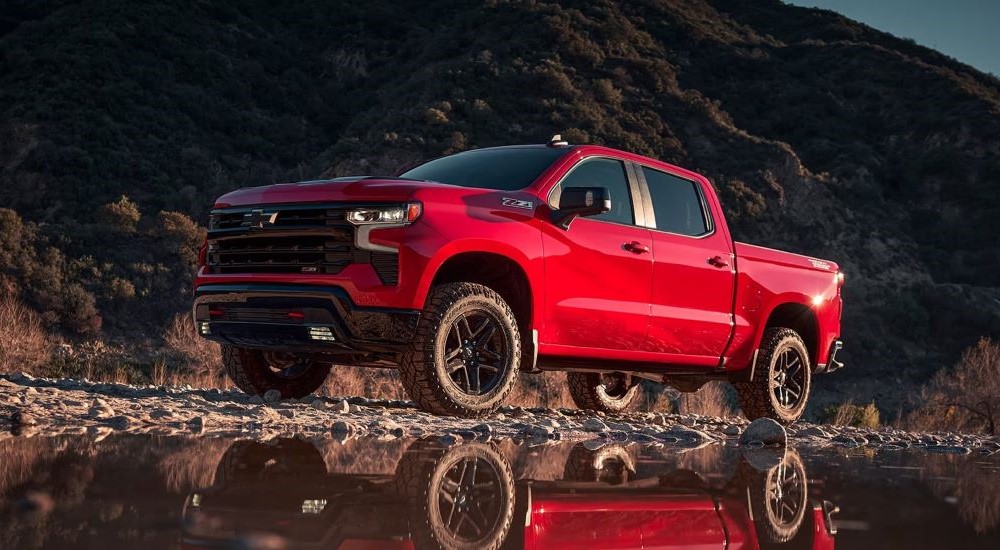 A red 2024 Chevy Silverado 1500 Z71 Trail Boss is shown from the front at an angle after leaving a Chevy Silverado dealer.