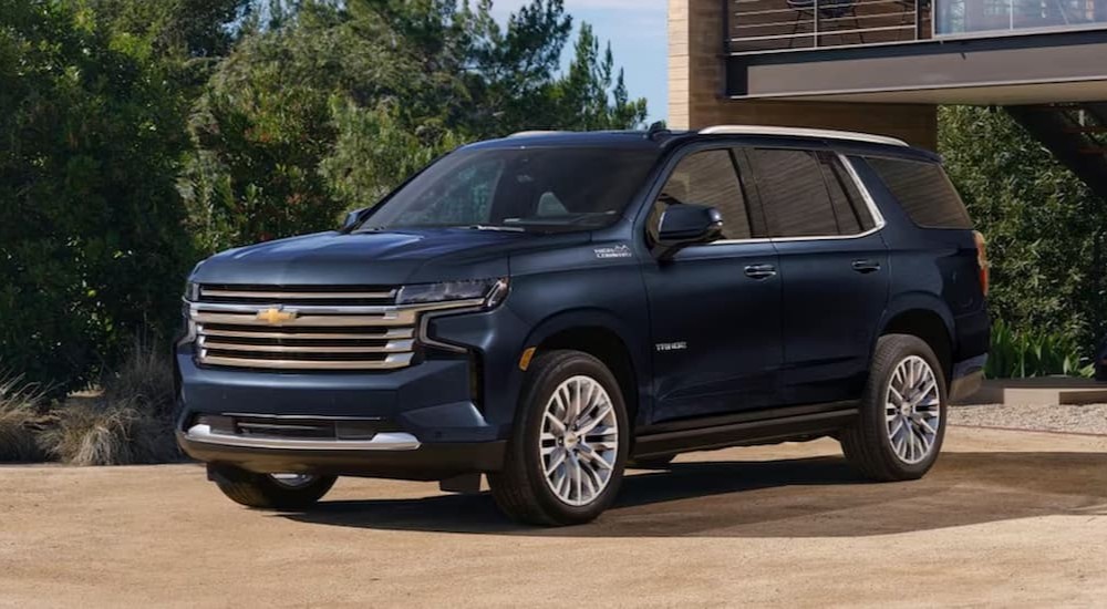 A blue 2023 Chevy Tahoe High Country is shown parked near the Woodlands Chevy dealer.