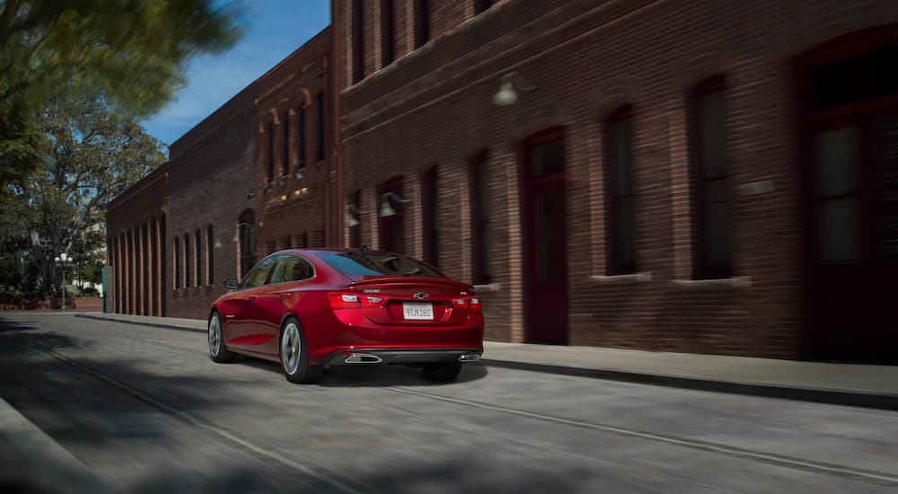 A red 2019 Chevy Malibu RS is shown from the rear at an angle after leaving a used Chevy dealer.