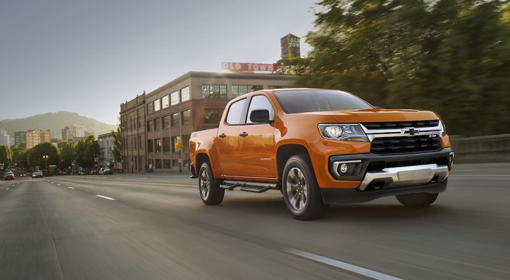 An orange 2021 Chevy Colorado Z71 is shown from the front at an angle.
