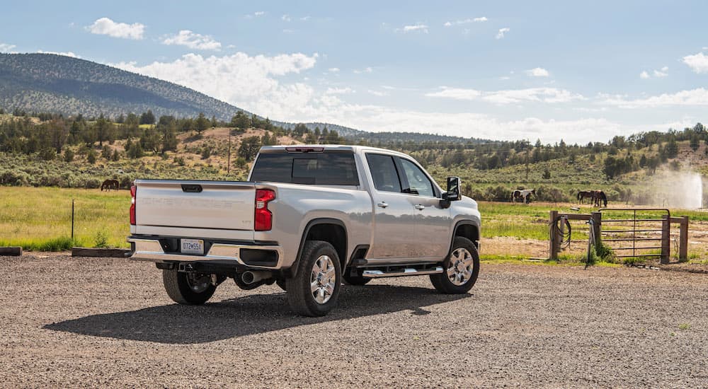 A silver 2022 Chevy Silverado 2500 HD is shown from the rear at an angle after leaving a truck dealer.