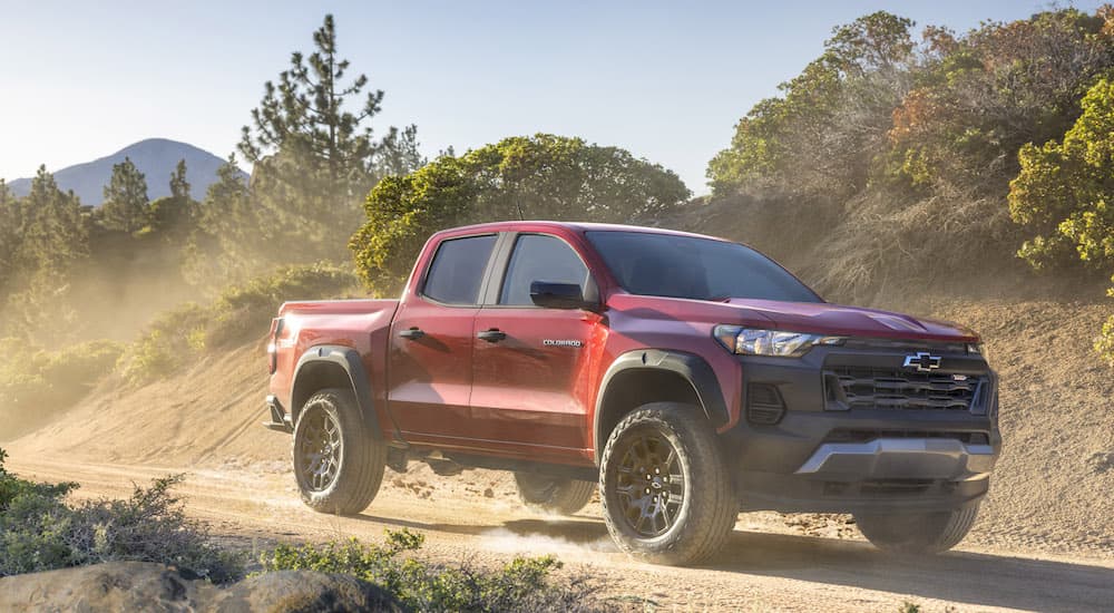 A red 2023 Chevy Colorado Trail Boss is shown from the front at an angle after leaving a truck dealer.
