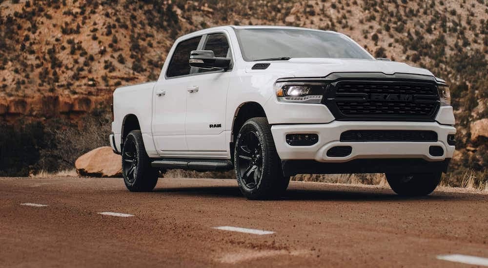 A white 2022 Ram 1500 is shown from the front at an angle after leaving a dealer that has used trucks for sale near Rayford.