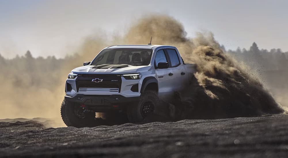 A silver 2024 Chevy Colorado ZR2 kicking up dust while off-roading.