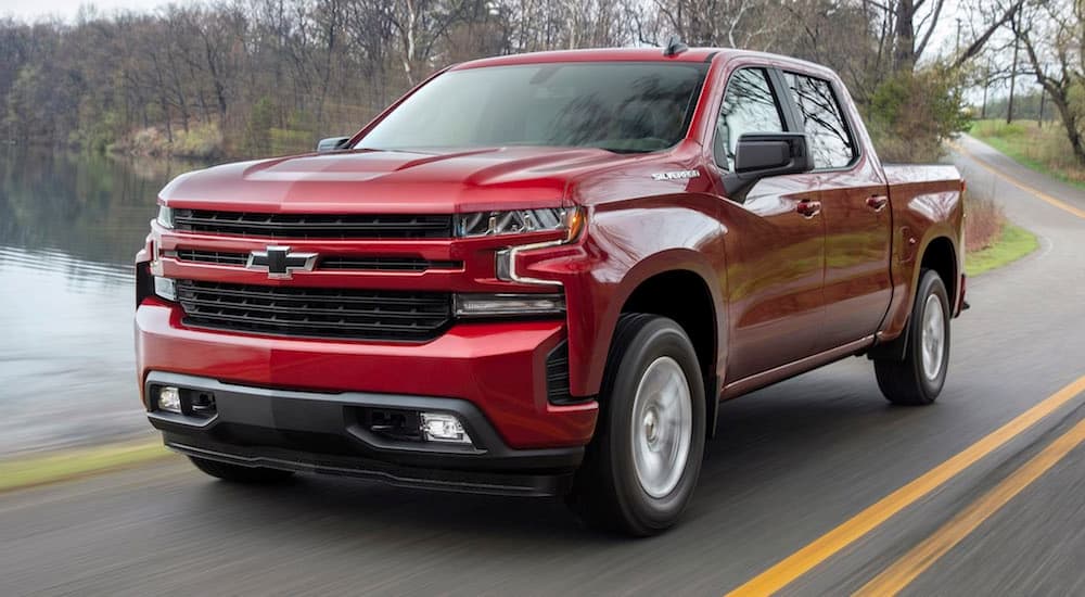 A red 2019 Chevy Silverado 1500 RST driving past a lake.