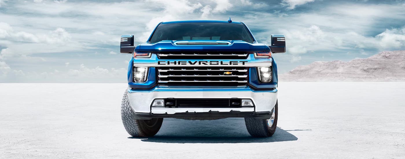 The front of a blue 2021 Chevy Silverado 2500HD is shown while parked in a desert.