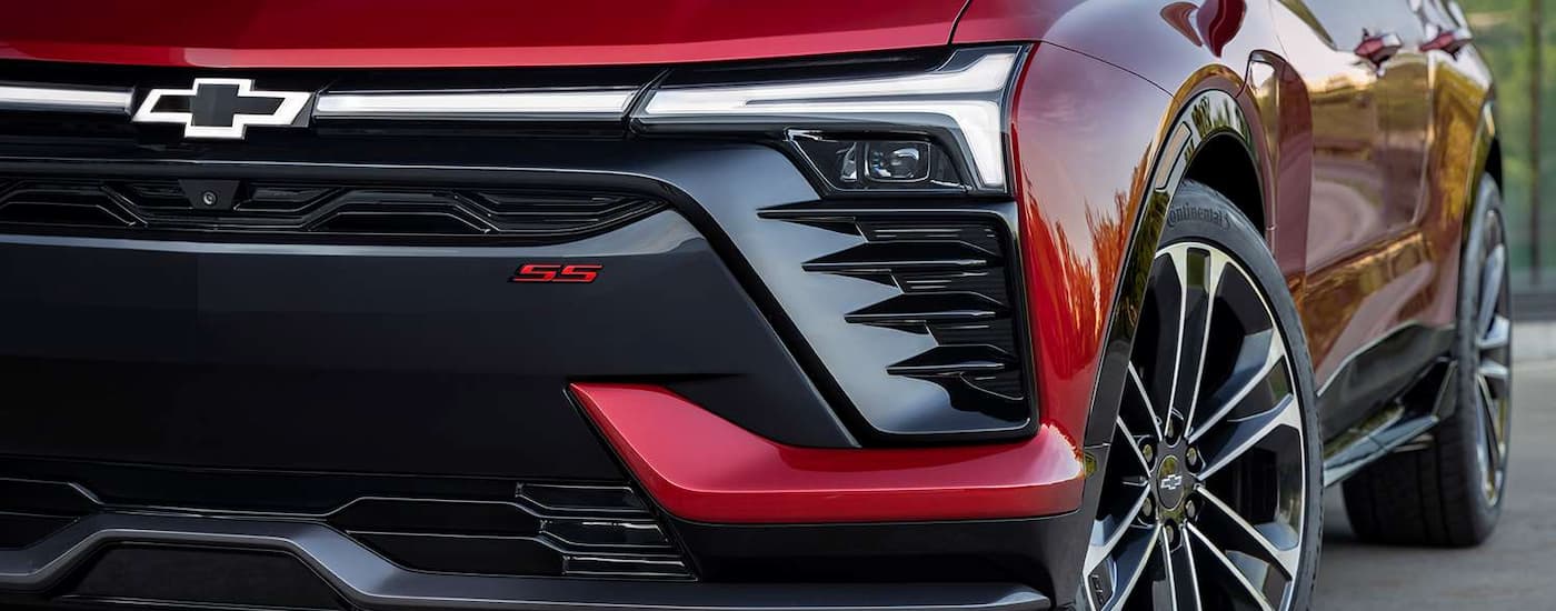 A close up of the front of a red 2024 Chevy Blazer EV SS shows the grille and headlight.