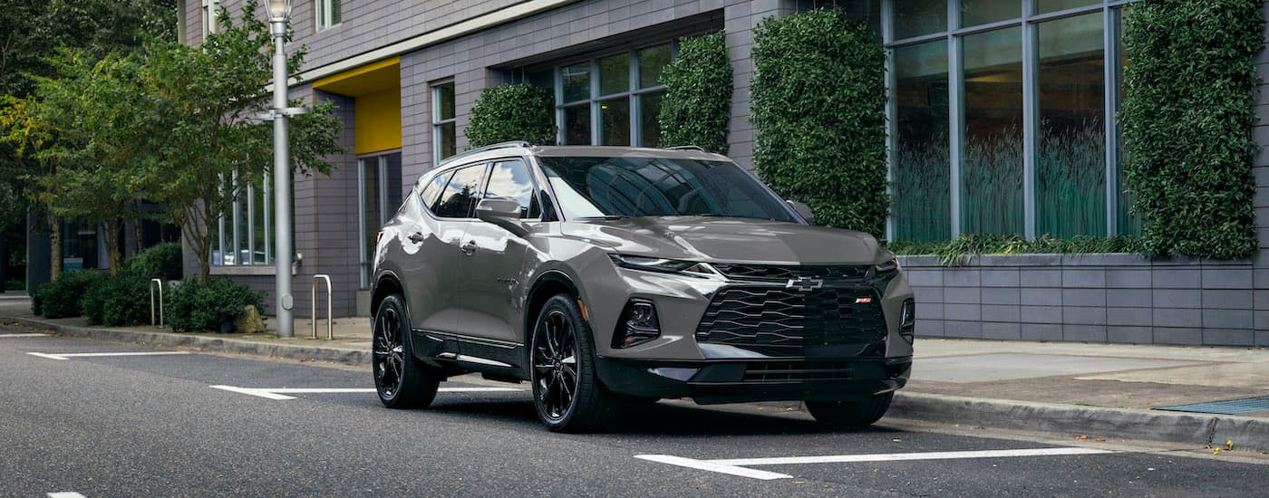 A dark grey 2020 Chevy Blazer RS is shown parked outside of a city building after visiting a certified pre-owned Chevy dealer.