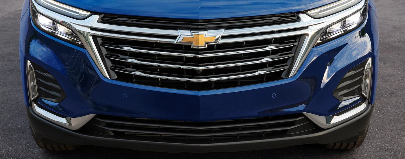 A close up of the grille on a blue 2023 Chevy Equinox is shown at a Chevy Equinox dealership.