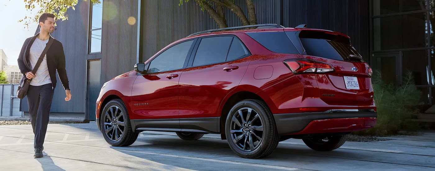 A red 2022 Chevy Equinox RS is shown parked on a city street.