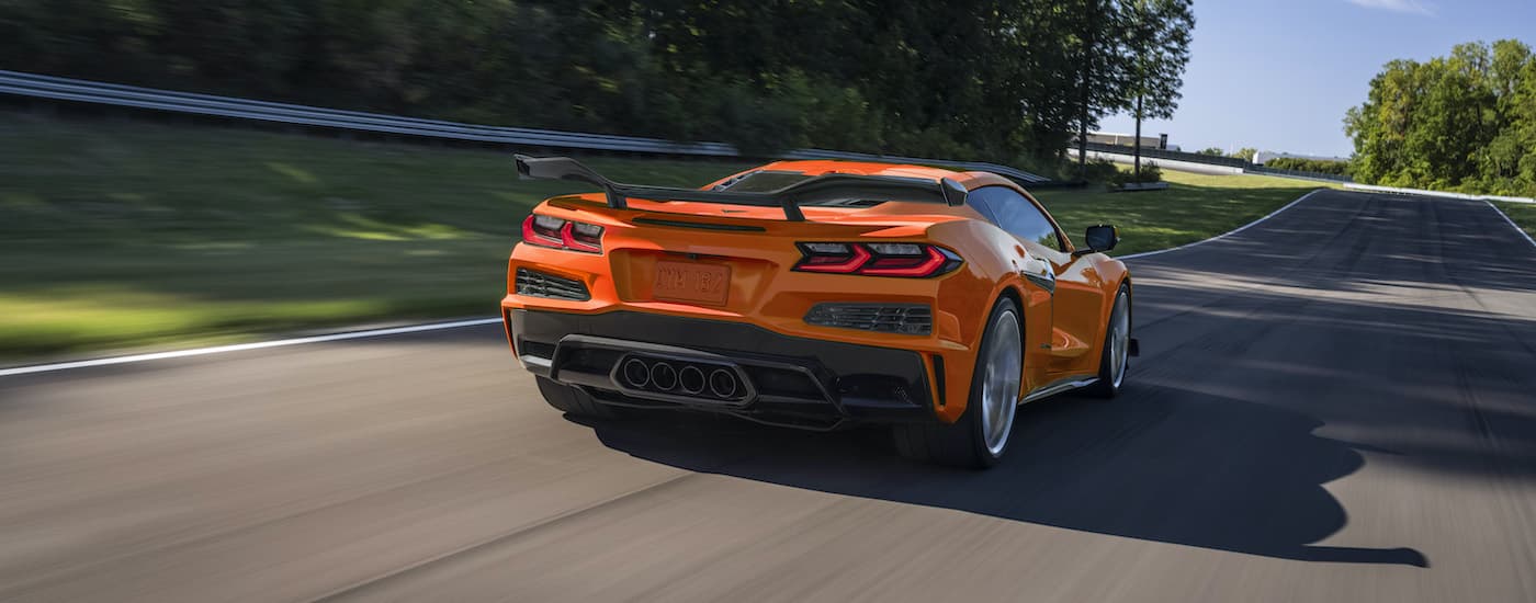 An orange 2023 Chevy Corvette Z06 is shown driving on an open road after going through the Chevy pre-order process.