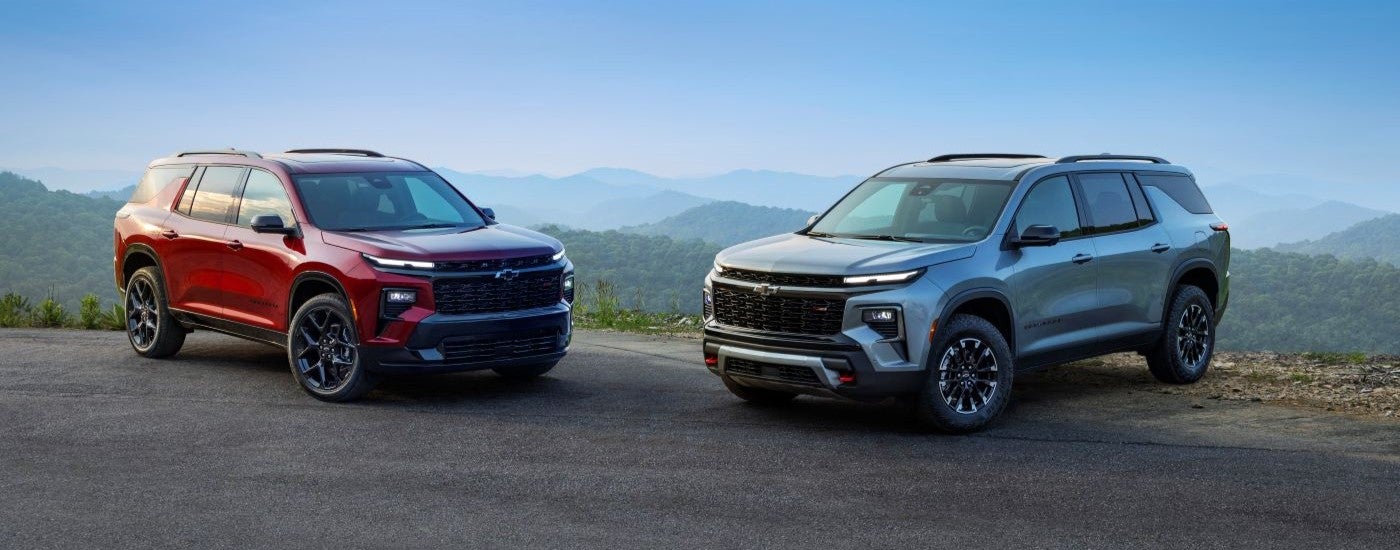 A red 2024 Chevy Traverse RS and a grey Z71 are shown facing each other.