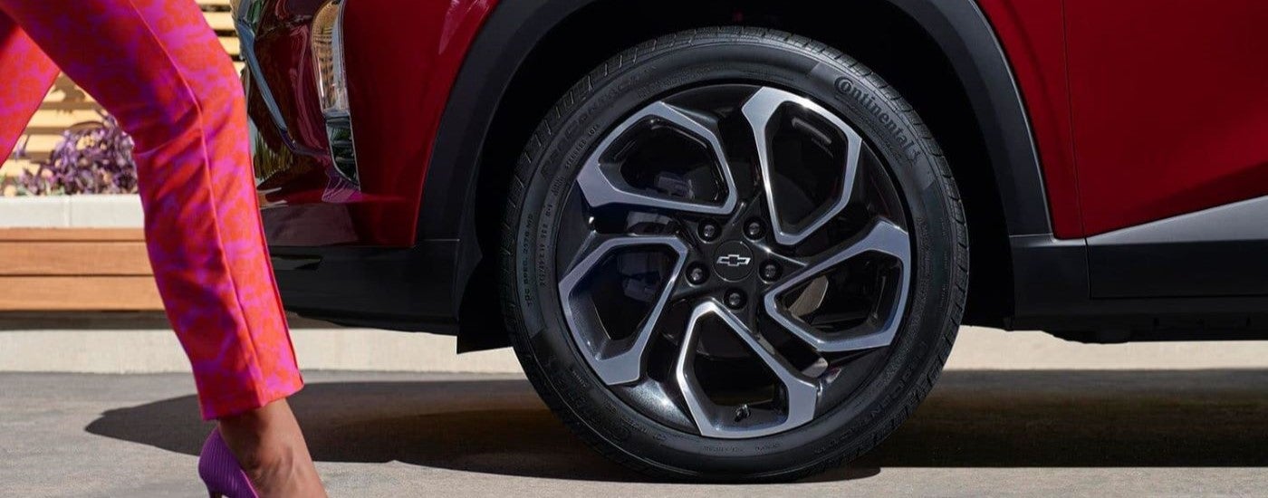 A close up show a chrome and black wheel on a red 2024 Chevy Trax RS.