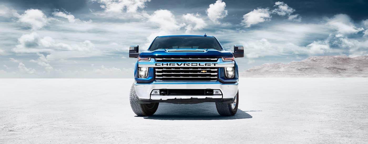 A blue 2022 Chevy Silverado 2500HD is shown from the front while parked on a salt flat.